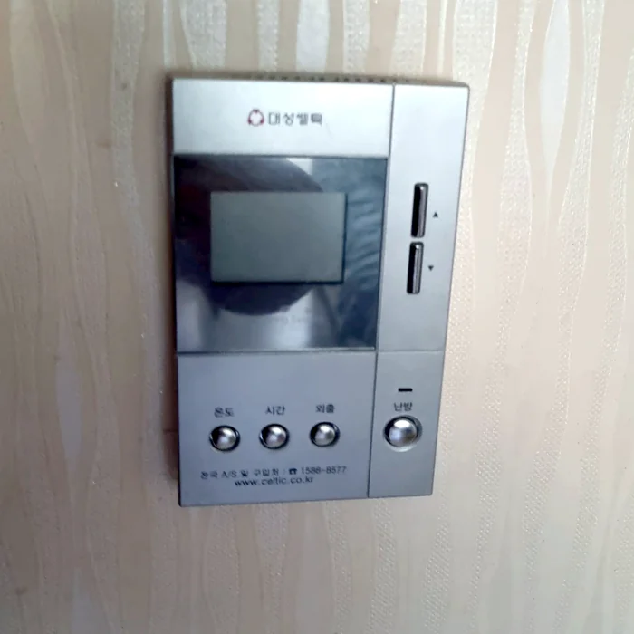 교체 전 무늬 벽지 벽면의 오래된 은색 온도조절기